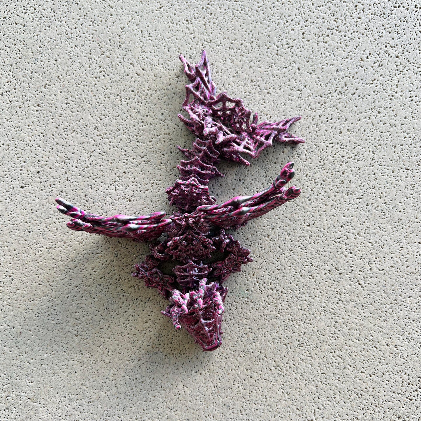 Intricate dragon figure with dark, swirling colors and elaborate wings, exuding a mysterious and enchanting aura.