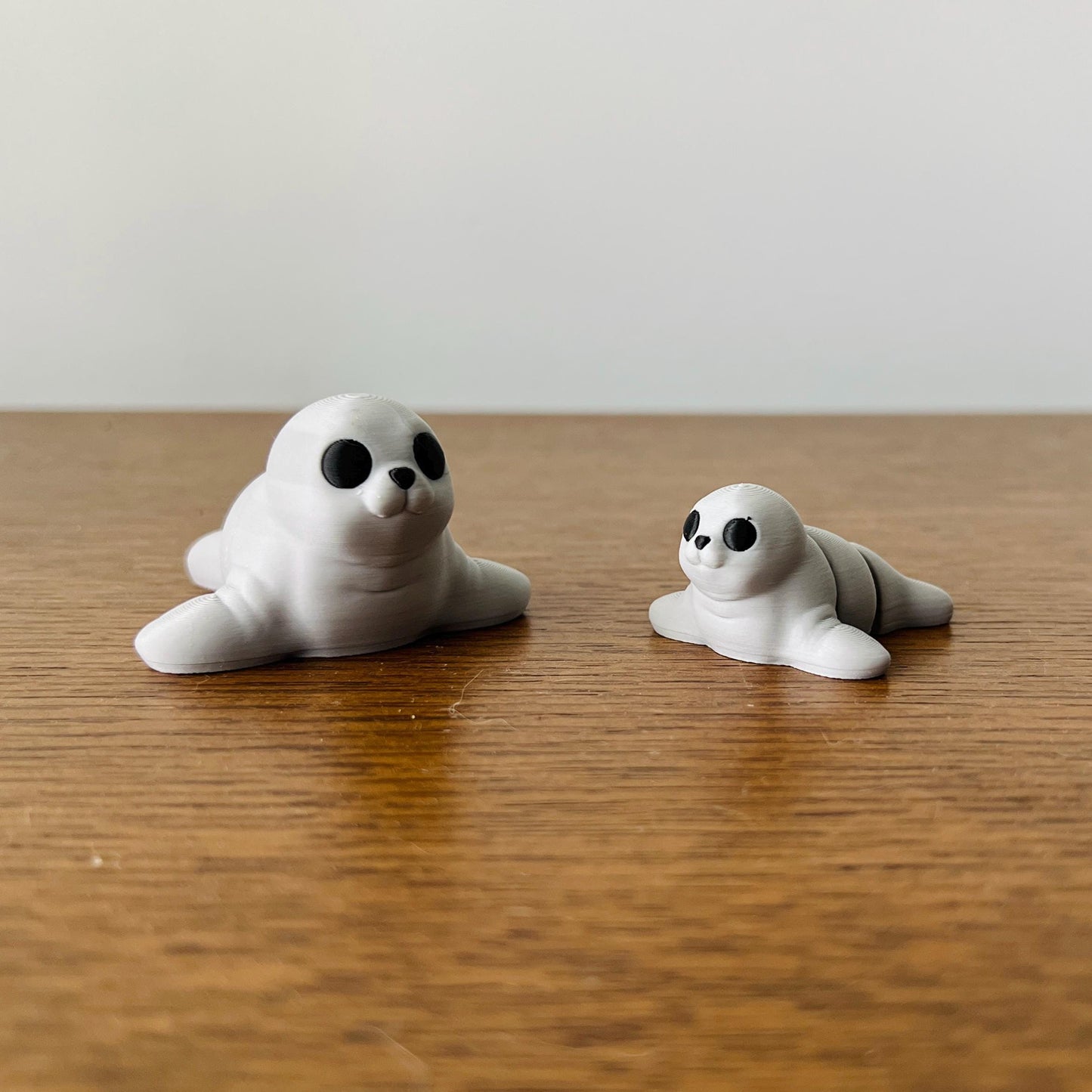 Adorable 3D printed seals in white with black eyes, perfect for sensory play and charming collectibles.