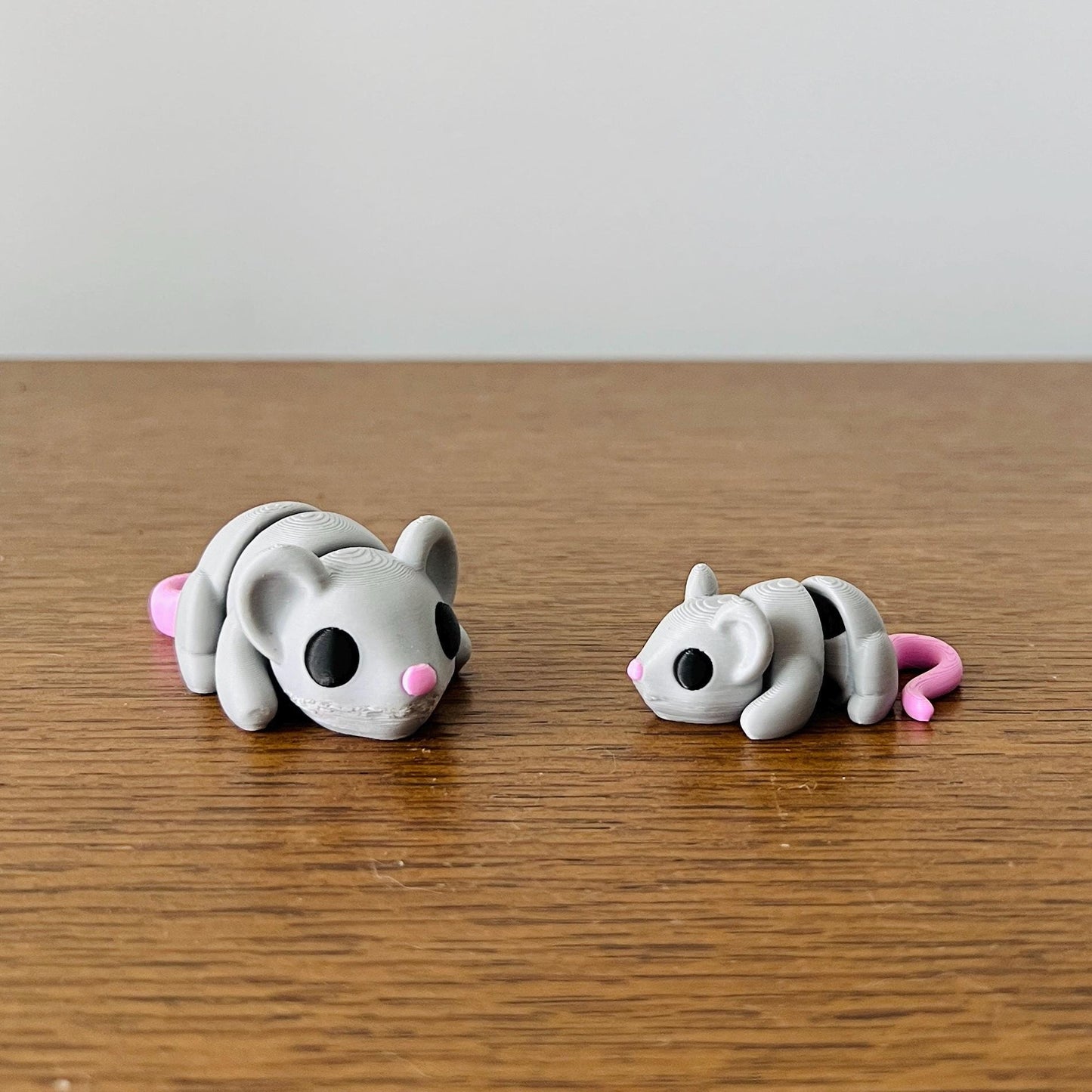 Adorable articulated mini mice in gray with pink accents, perfect for sensory play and stress relief.