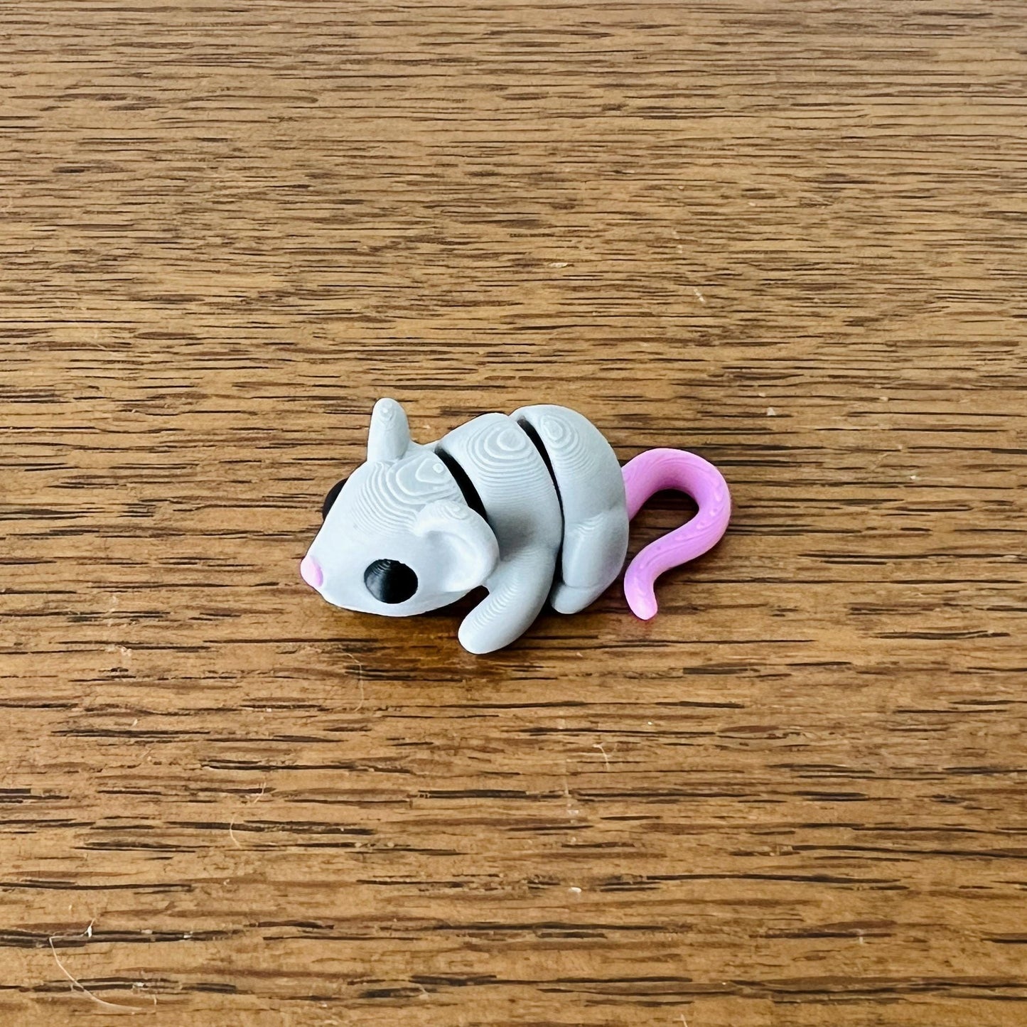 Adorable gray-and-pink articulated mouse with flexible parts, perfect for sensory play and stress relief.