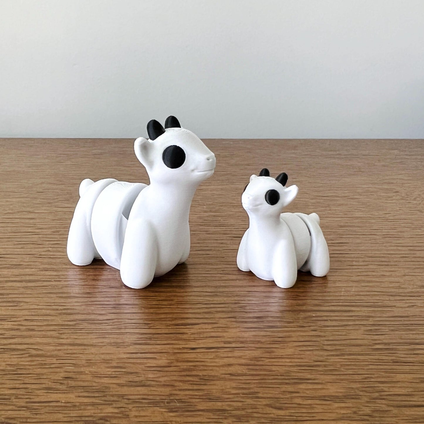 Charming white mini goats with black accents, featuring articulated joints for a tactile and playful experience.