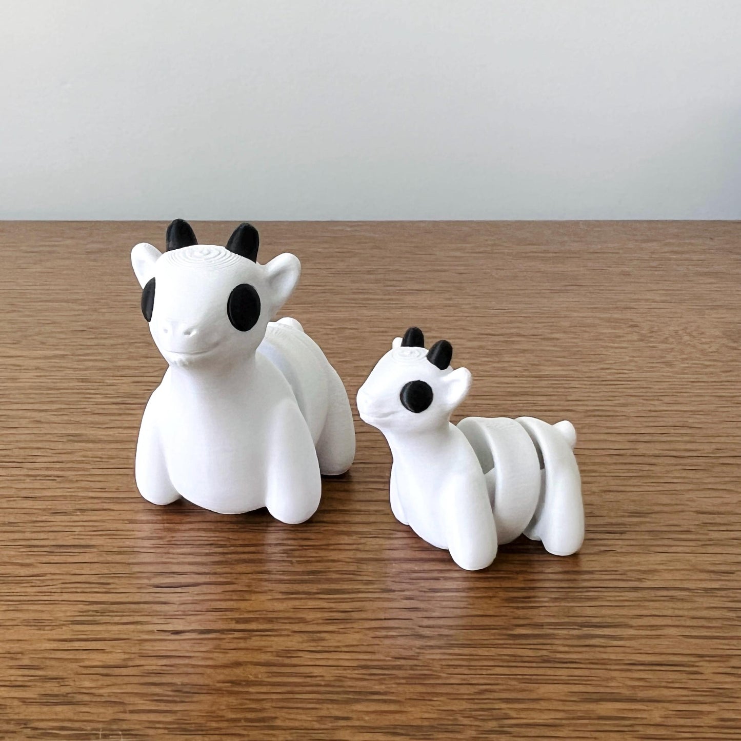 Charming 3D printed mini goats in white with black accents, perfect for sensory play and quirky collectibles.
