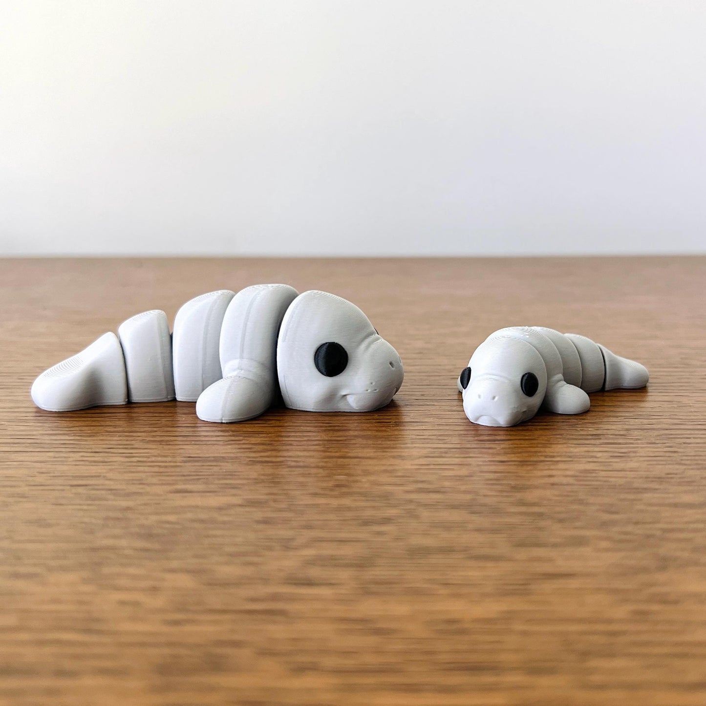Adorable articulated mini manatees in soft gray, perfect for tactile play and stress relief. Ideal for all ages.