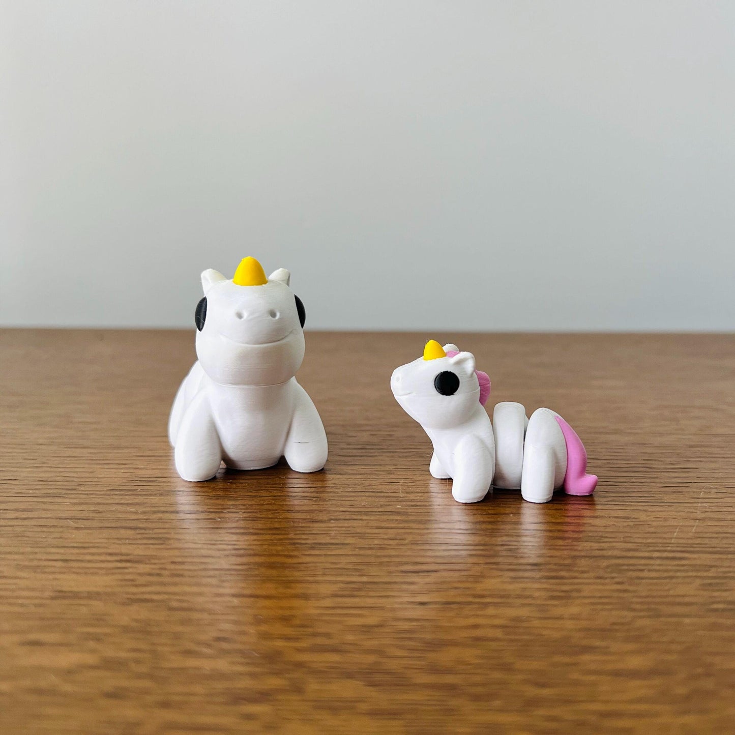 Adorable mini unicorns with pink manes and yellow horns, perfect for sensory play and whimsical charm.