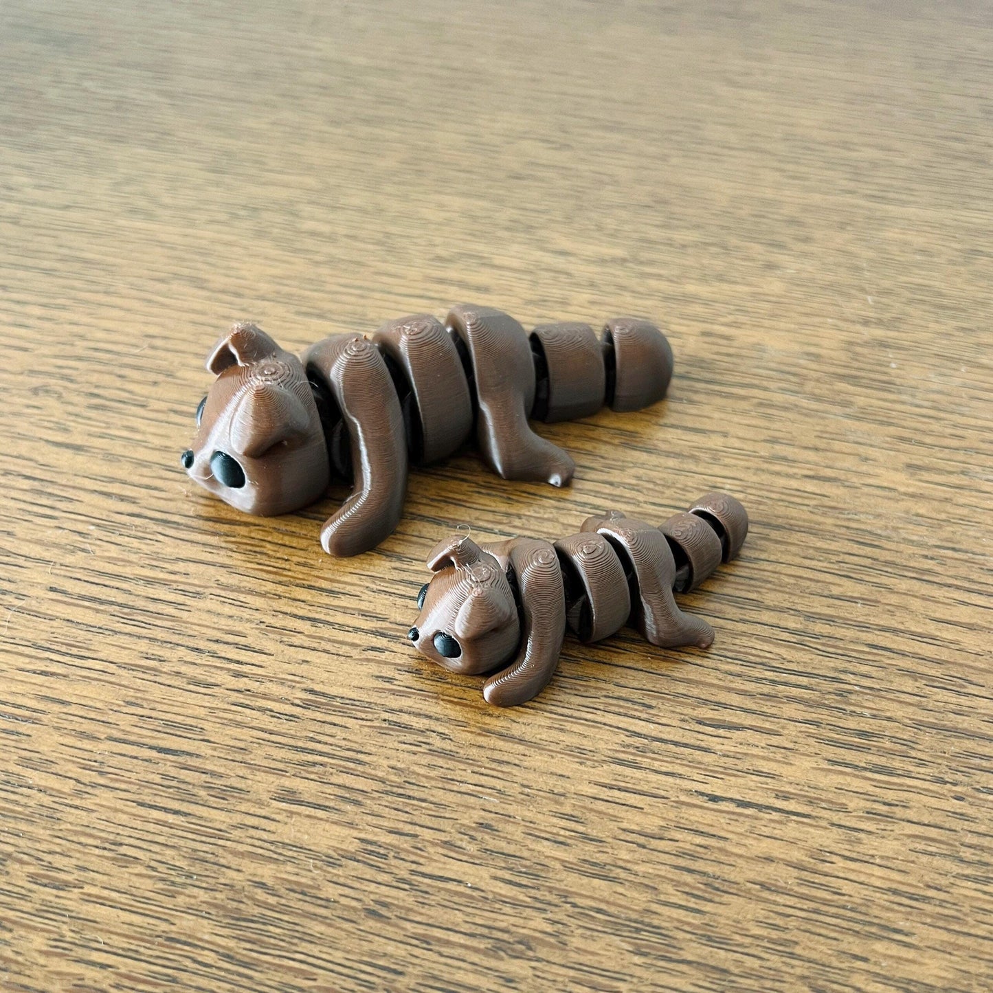 Adorable brown mini puppy figures with black accents, perfect for sensory play or as charming collectibles.