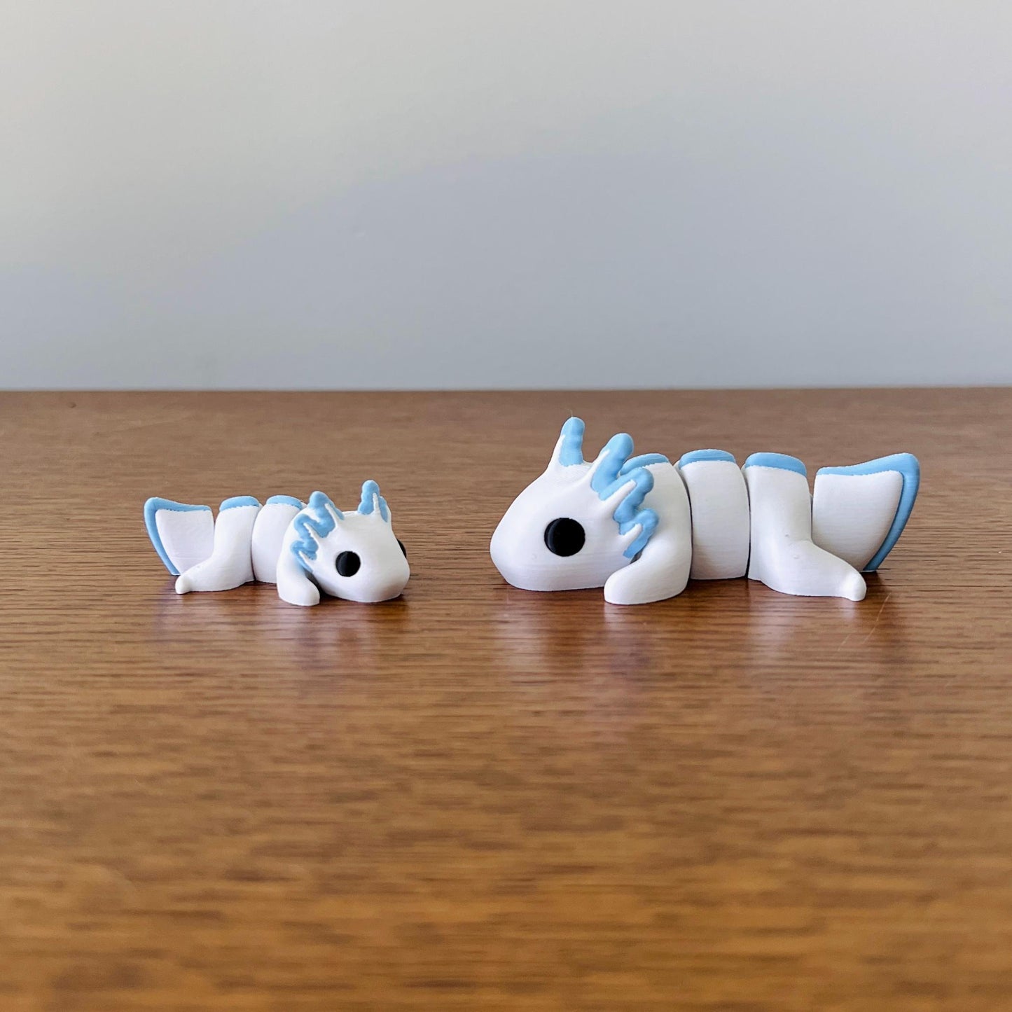 Charming white and pastel blue axolotls with articulated bodies, perfect for sensory play and stress relief.