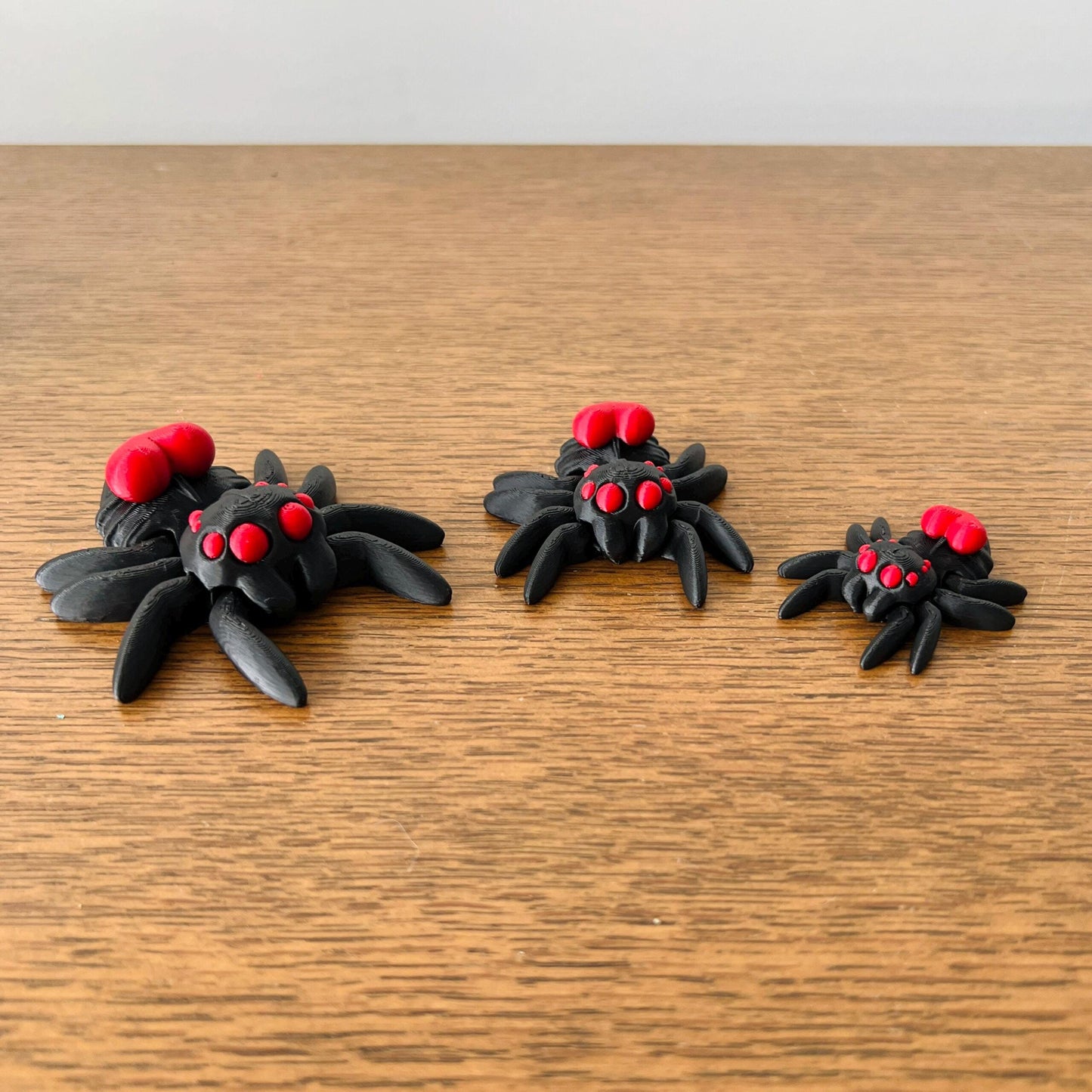 Adorable mini black spiders with red hearts on their backs, perfect for adding charm to any collection.
