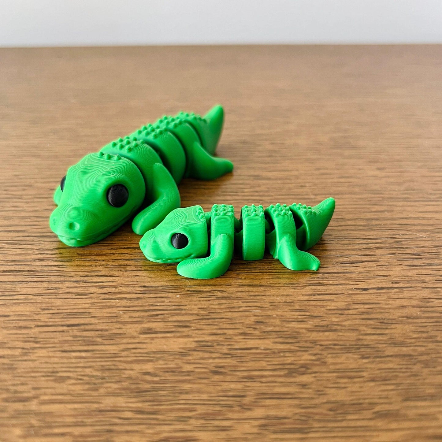 Two vibrant green crocodile figures with detailed textures, perfect for fidgeting or as unique collectibles.