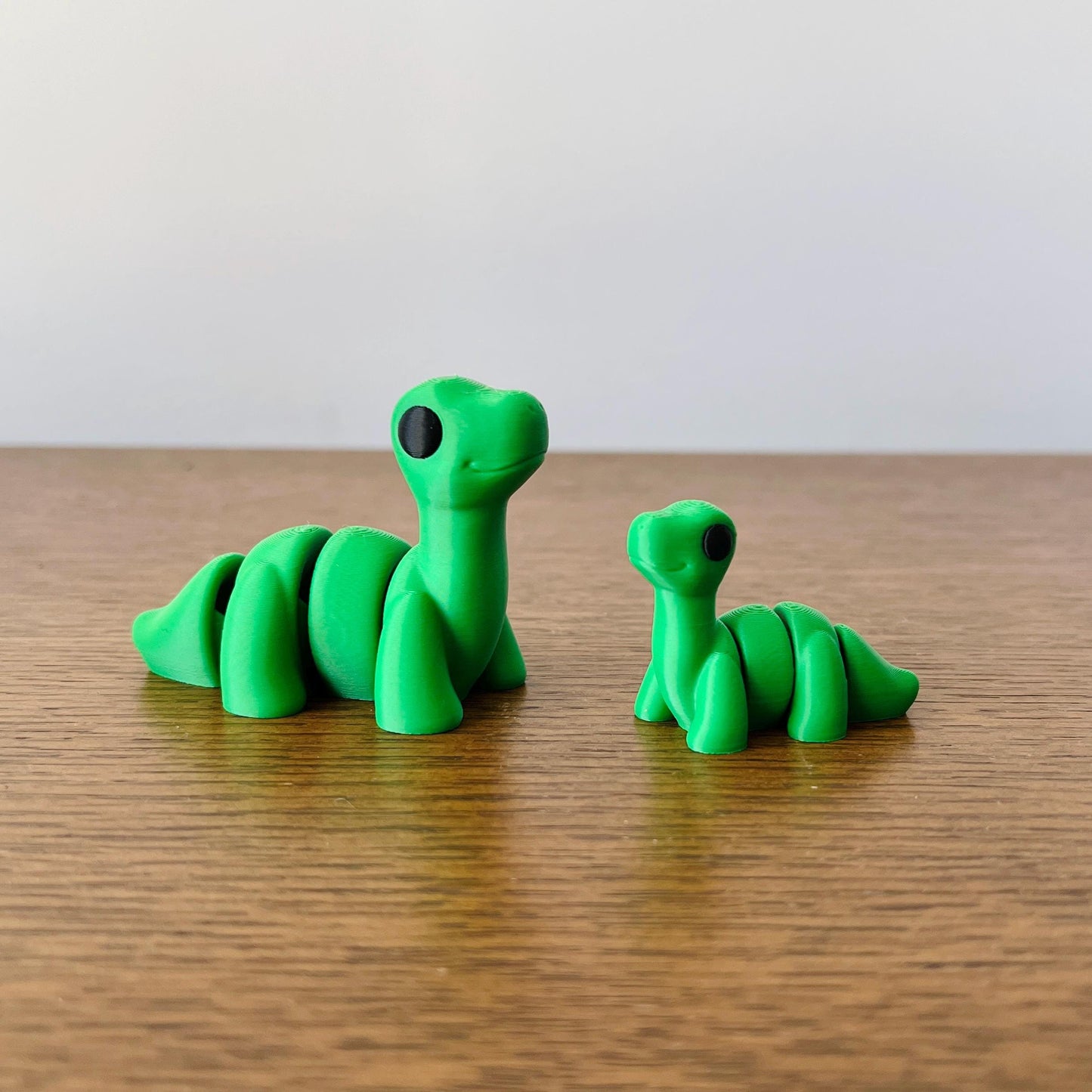 Charming green Brontosaurus figures with detailed long necks, perfect for dinosaur enthusiasts and collectors.