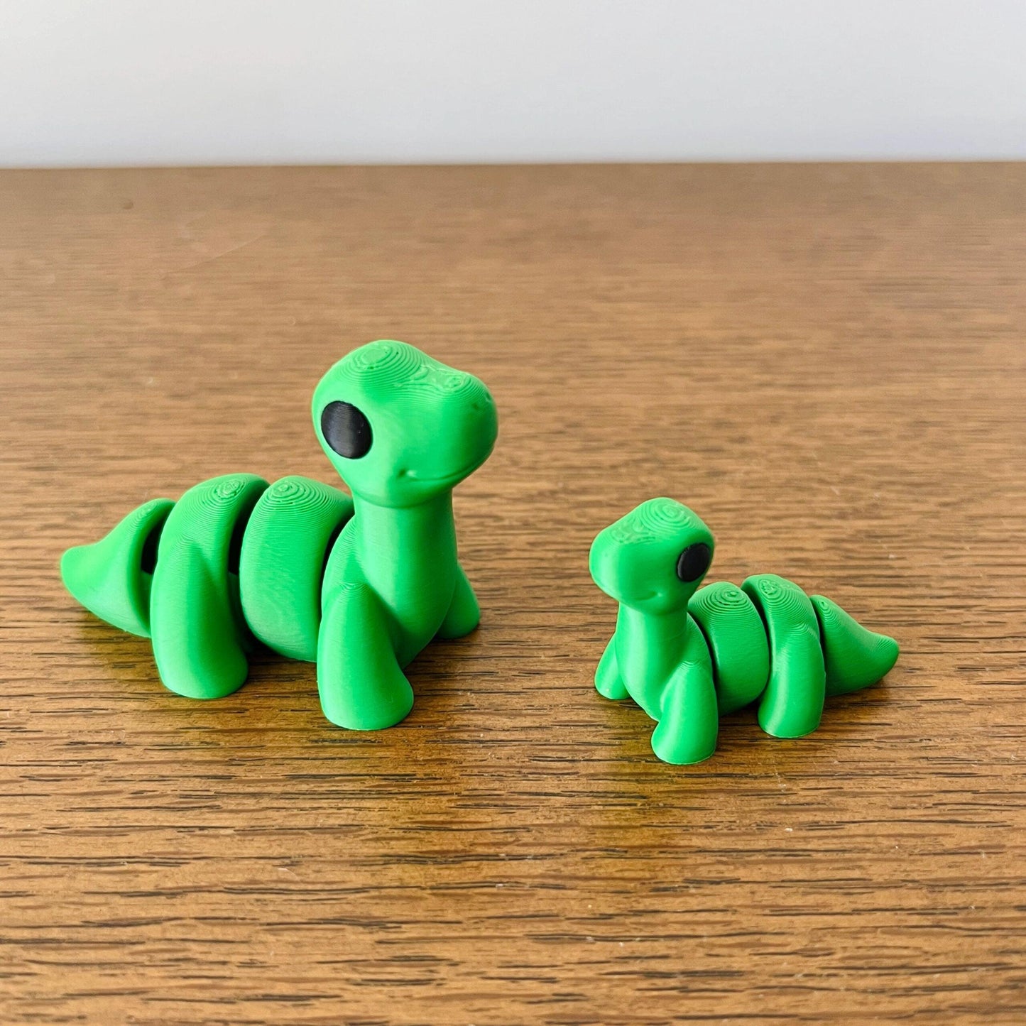 Charming green Brontosaurus figures with intricate details, showcasing their classic long necks and friendly expressions.