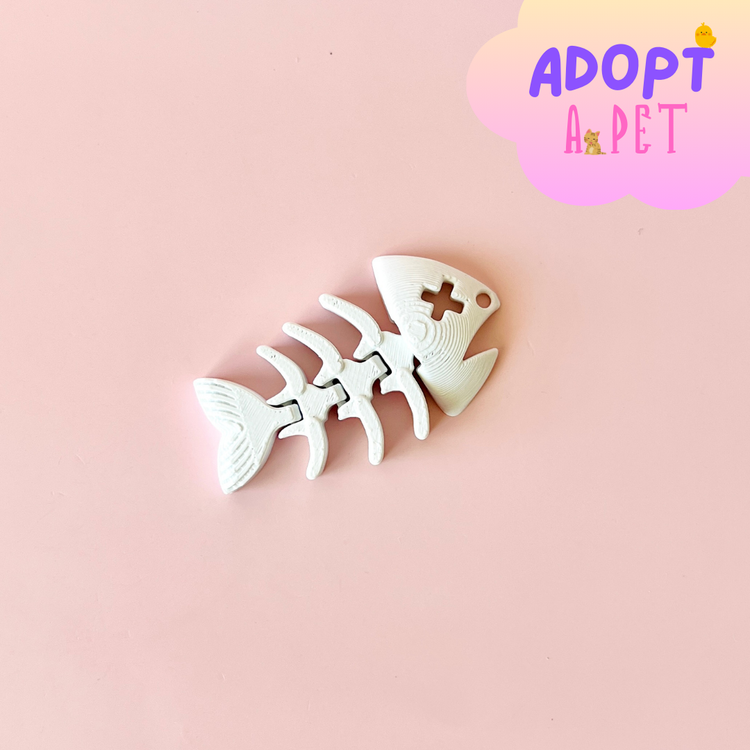 A playful white fish skeleton rests on a soft pink background, with a colorful "ADOPT A PET" banner above.