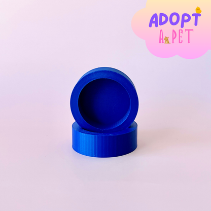 Two stacked blue circular shapes with a smooth finish, set against a soft pastel background.