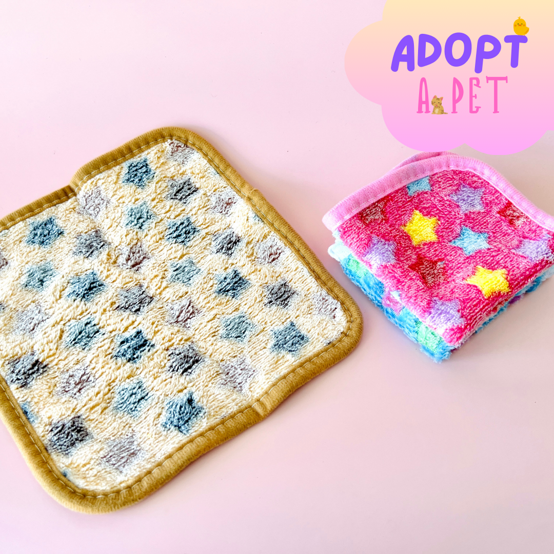 Two colorful textured cloths on a pink background, with a playful "ADOPT A PET" graphic above.