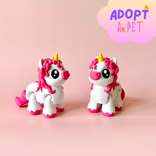 Two whimsical unicorn figures with pink manes and golden horns, set against a soft pink background.