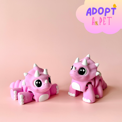 Two cute pink creatures with large eyes and white spikes, set against a soft pink background.