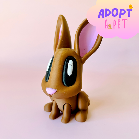 Brown rabbit figure with large black eyes and pink ears, set against a soft pink background.