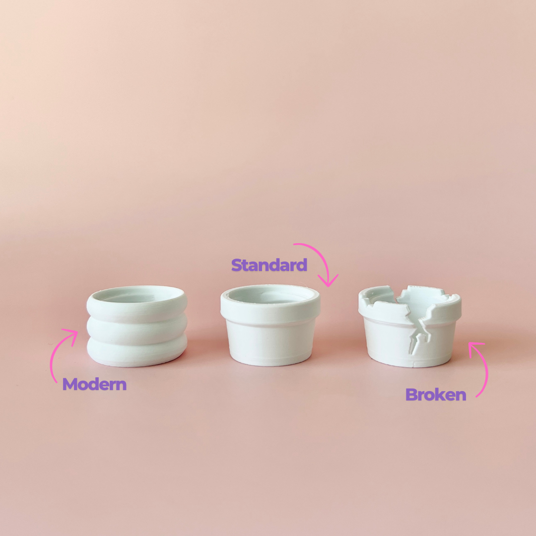 Three white pots in varying styles: modern with grooves, standard, and a broken one with a jagged edge, set against a pink ba