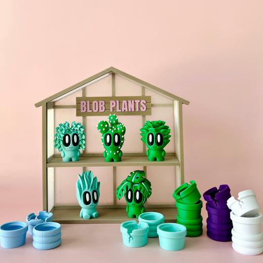 Colorful, whimsical plant figures with large eyes displayed on shelves, alongside vibrant pots in various colors.