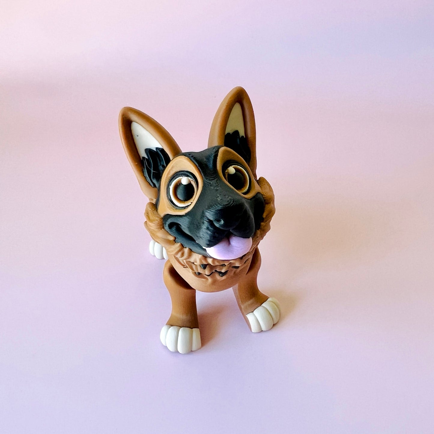 A cheerful German Shepherd figure with large eyes, floppy ears, and a playful stance against a pink background.