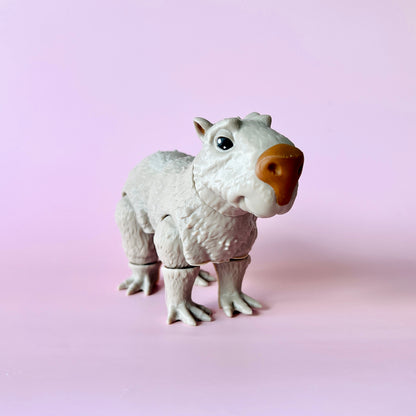 A whimsical creature with a fluffy white body and a pronounced orange nose against a soft pink background.