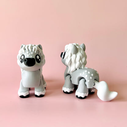 Two cute gray figures with fluffy manes and expressive eyes, set against a soft pink background.