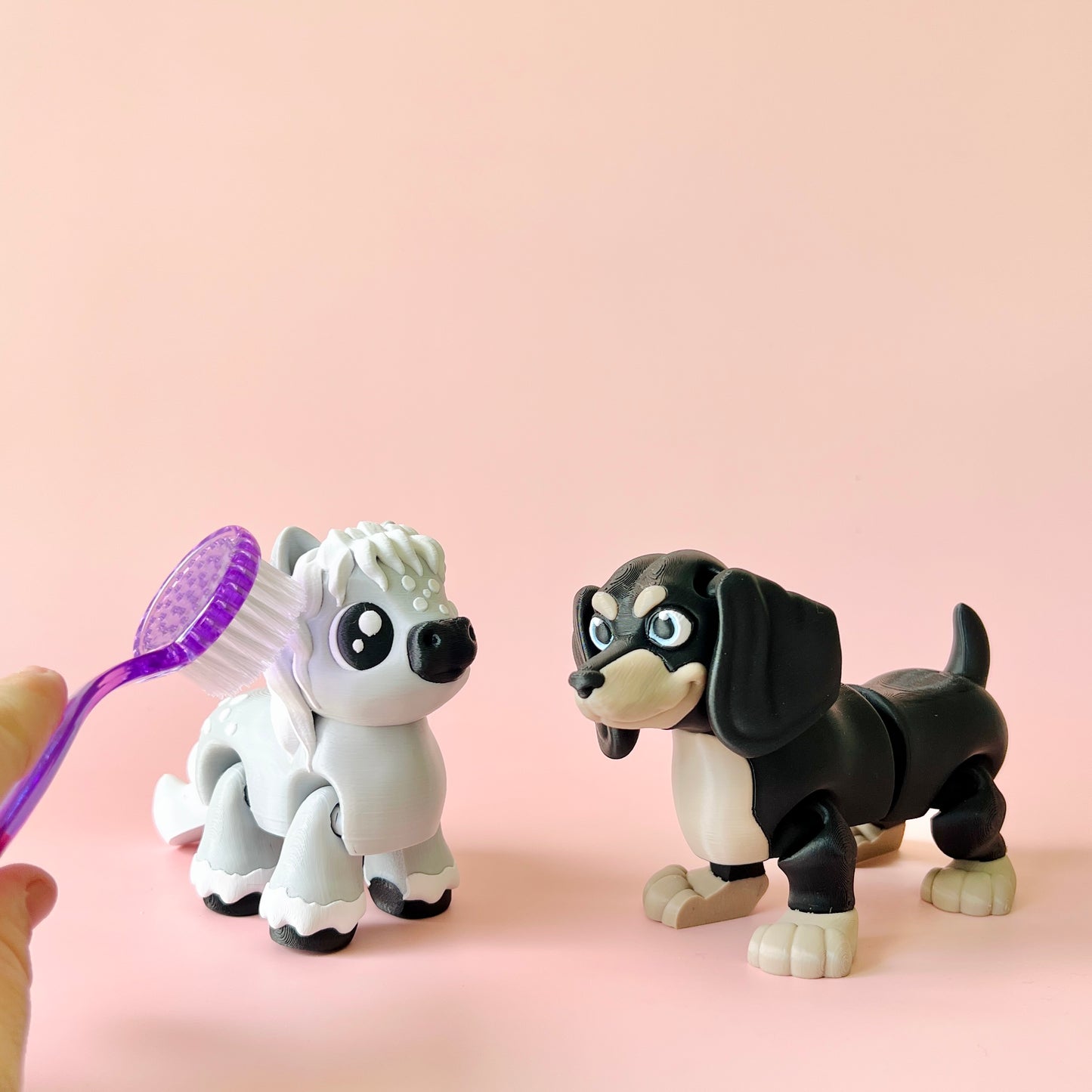 Two cartoonish dog figures, one white with a fluffy head and another black and tan, with a purple brush in hand.