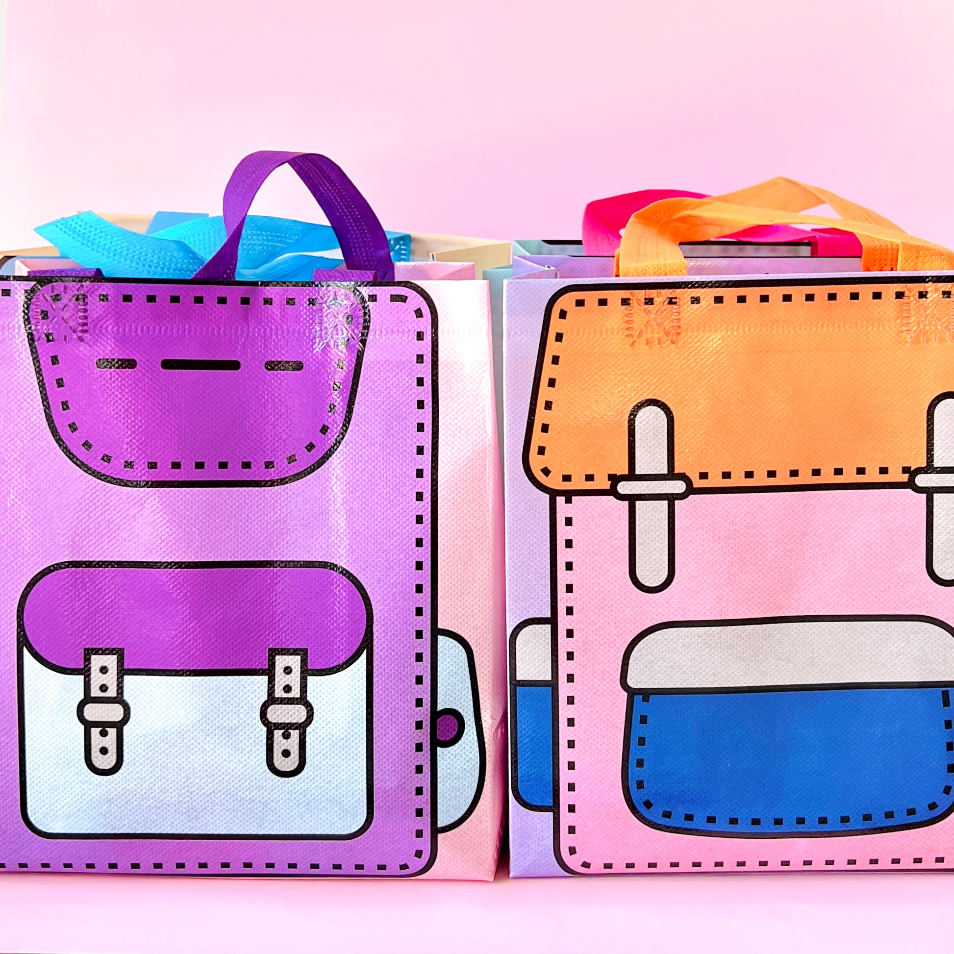 Colorful bags with playful backpack designs, featuring bold outlines and vibrant handles on a soft pink background.