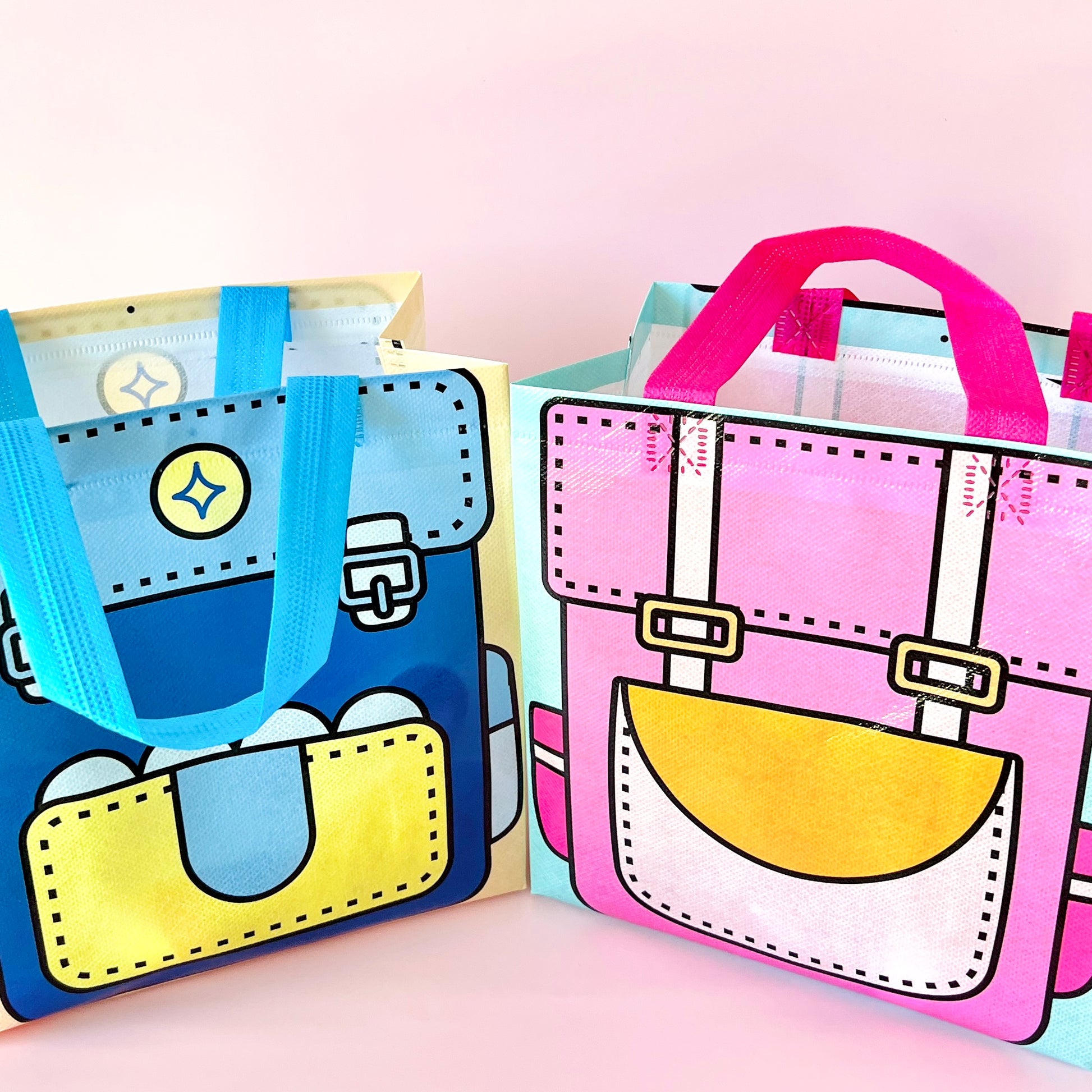 Two colorful bags resembling backpacks, one blue with yellow accents, the other pink with a cheerful yellow face.