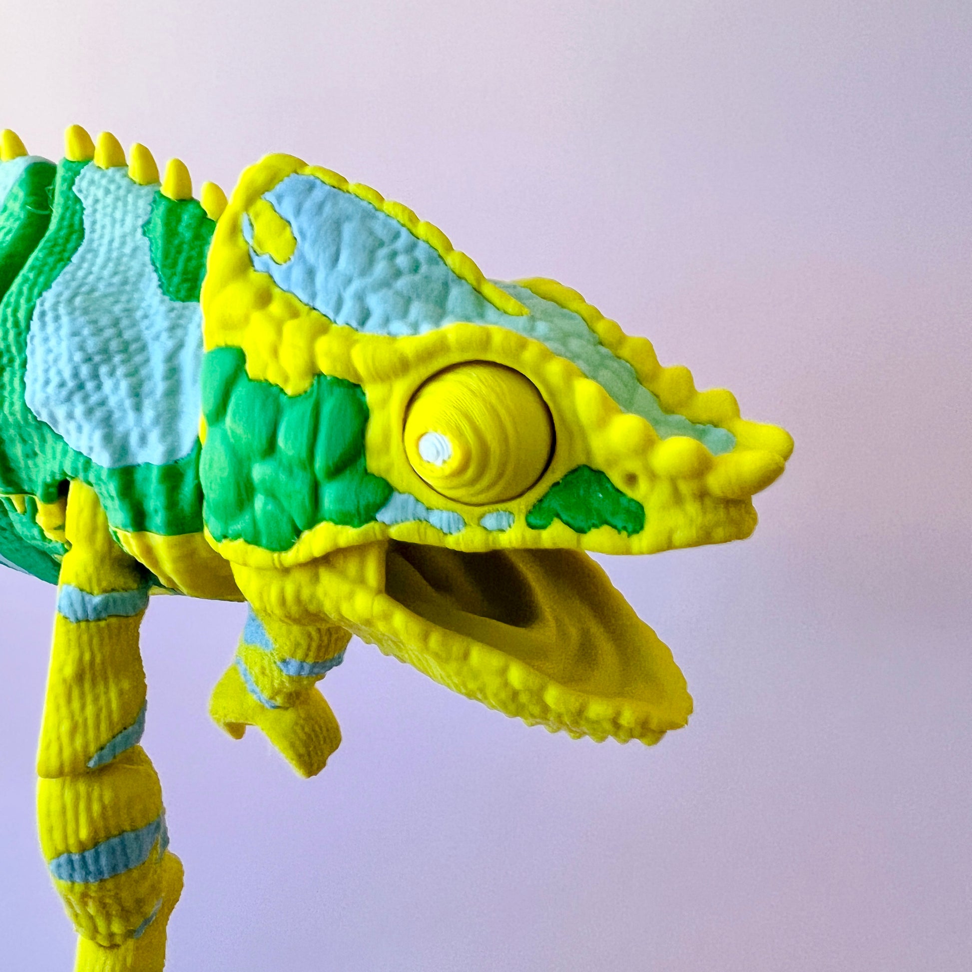 Colorful chameleon with textured skin, featuring vibrant green and yellow hues, posed against a soft background.