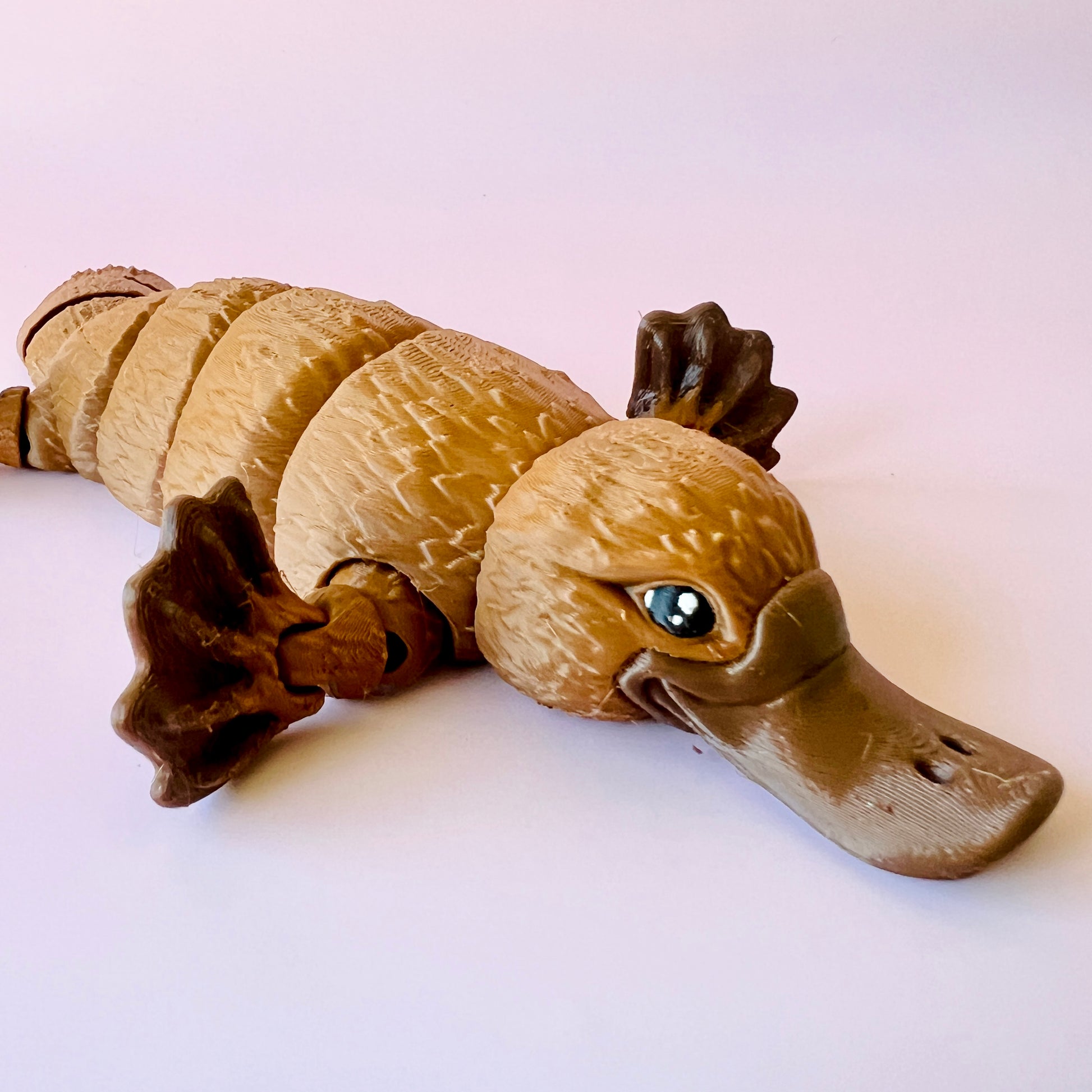 A stylized, articulated animal with a beaver-like body and duck-like head, featuring textured fur and bright eyes.