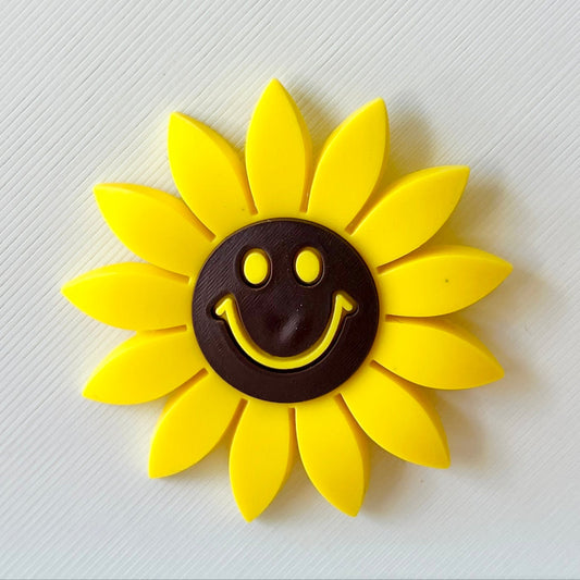 Bright yellow sunflower with a smiling face, set against a textured white background.