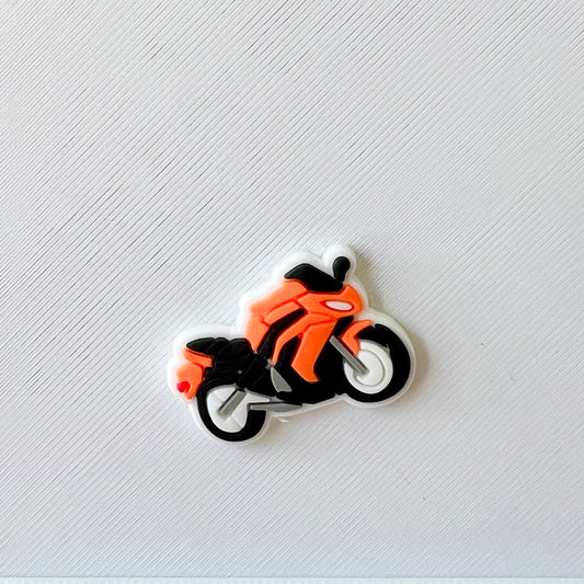 Bright orange motorcycle on a textured white background, showcasing sleek lines and contrasting black details.