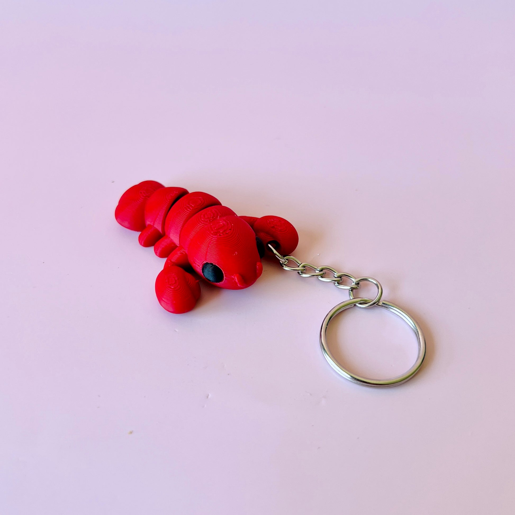Bright red lobster figurine with a keychain attachment, featuring detailed texture and large black eyes.