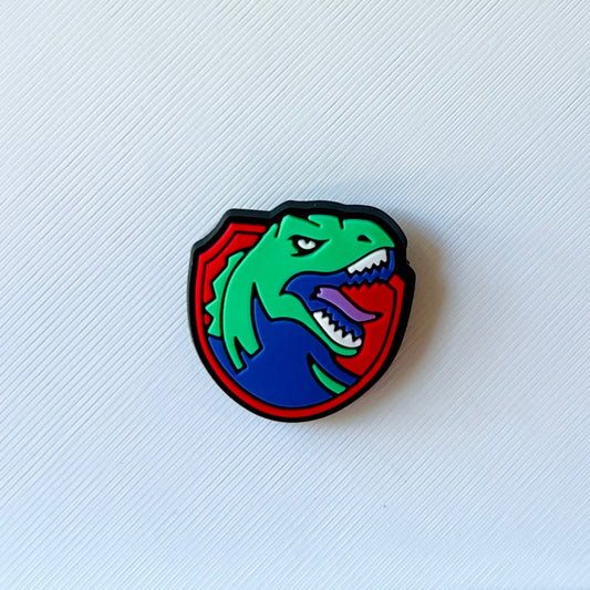 Colorful dinosaur emblem featuring a fierce expression, outlined in black, set against a textured white background.