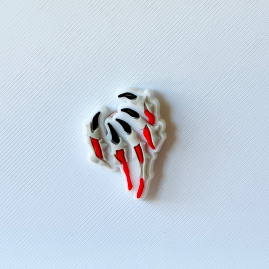 Colorful abstract shapes with red, black, and white accents against a textured white background, creating a playful visual.