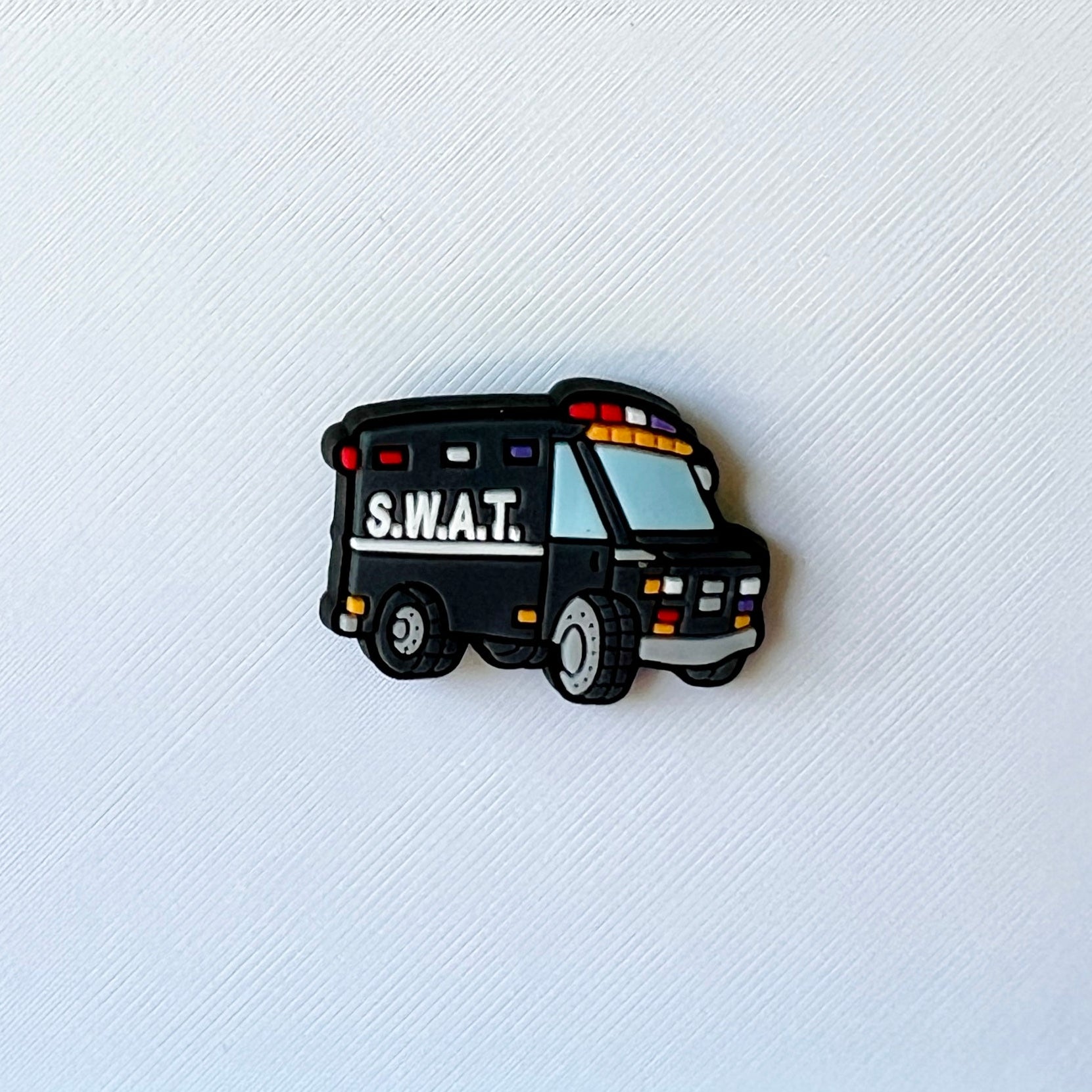A black vehicle with "S.W.A.T." written on the side, featuring colorful lights and cartoonish design elements.