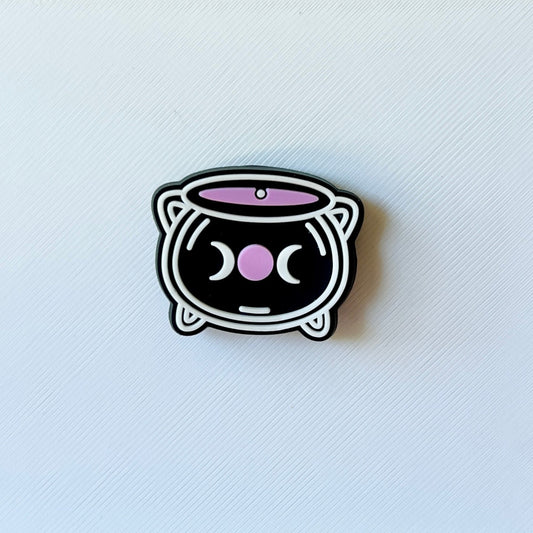 A cute, black cat-shaped container with pink accents and a whimsical face, set against a textured white background.