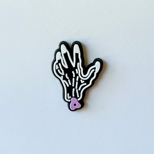 A whimsical hand illustration with black outlines and a pink heart detail, displayed on a textured white background.