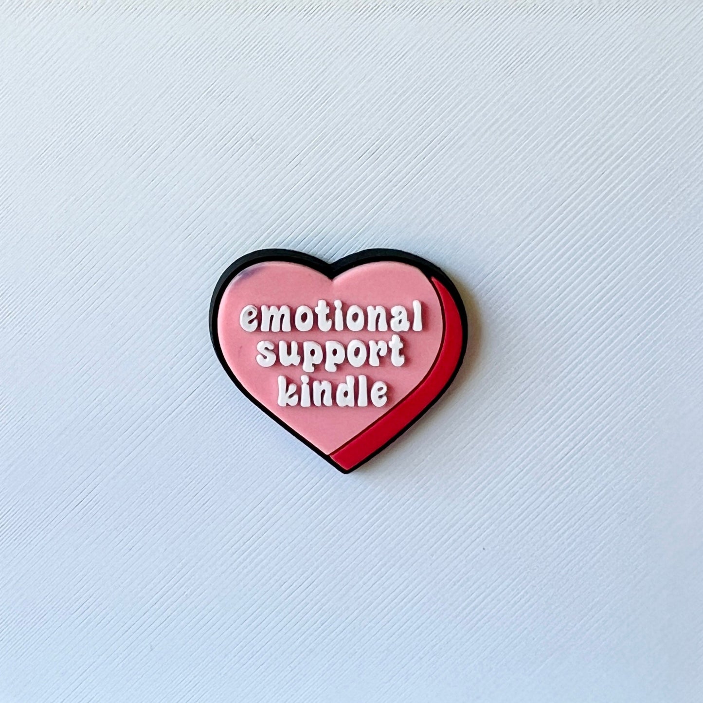 Heart-shaped graphic featuring the text "emotional support kindle" in bold white letters on a pink and red background.