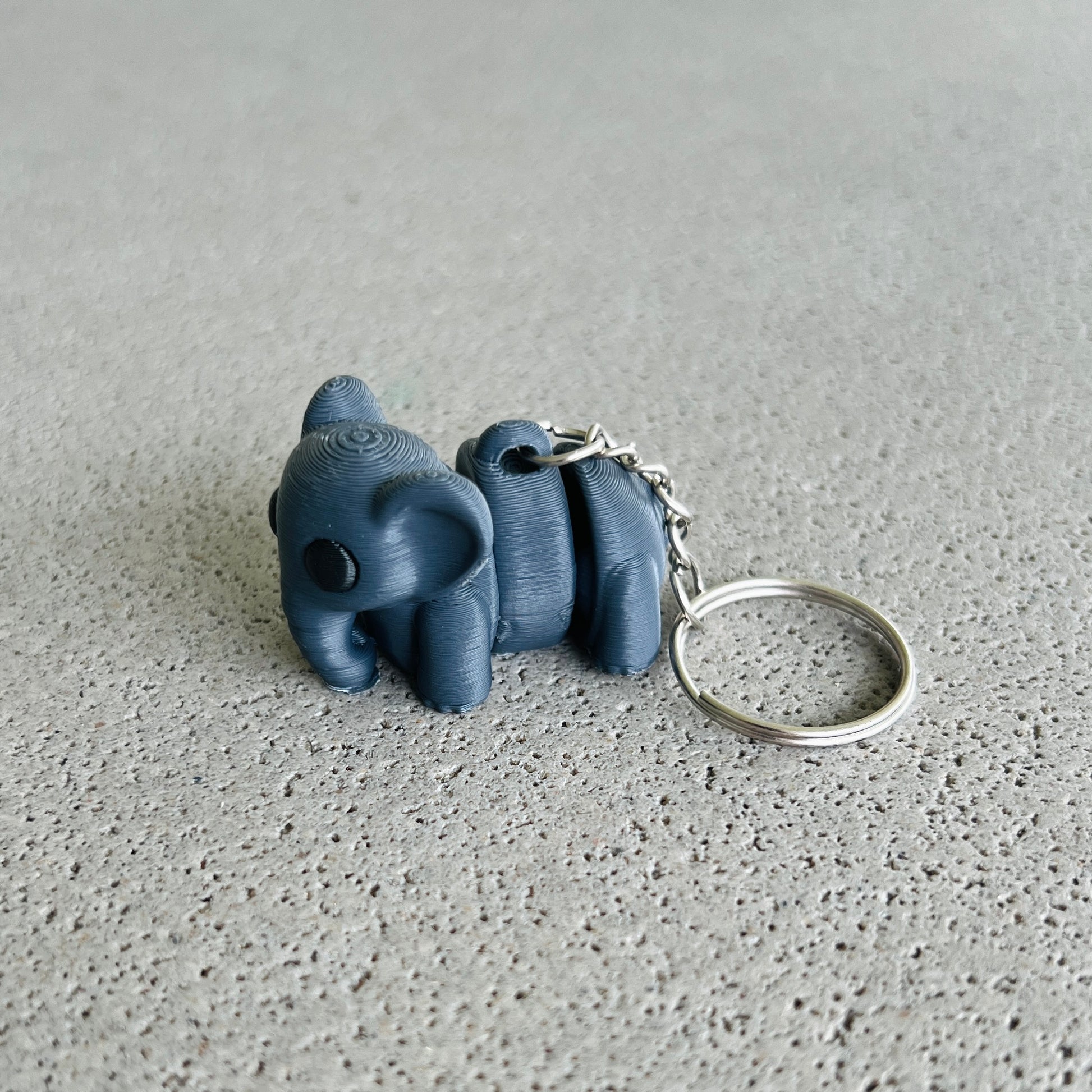 Charming dark grey elephant keychain with a playful design, perfect for keeping keys organized and adding a fun touch.