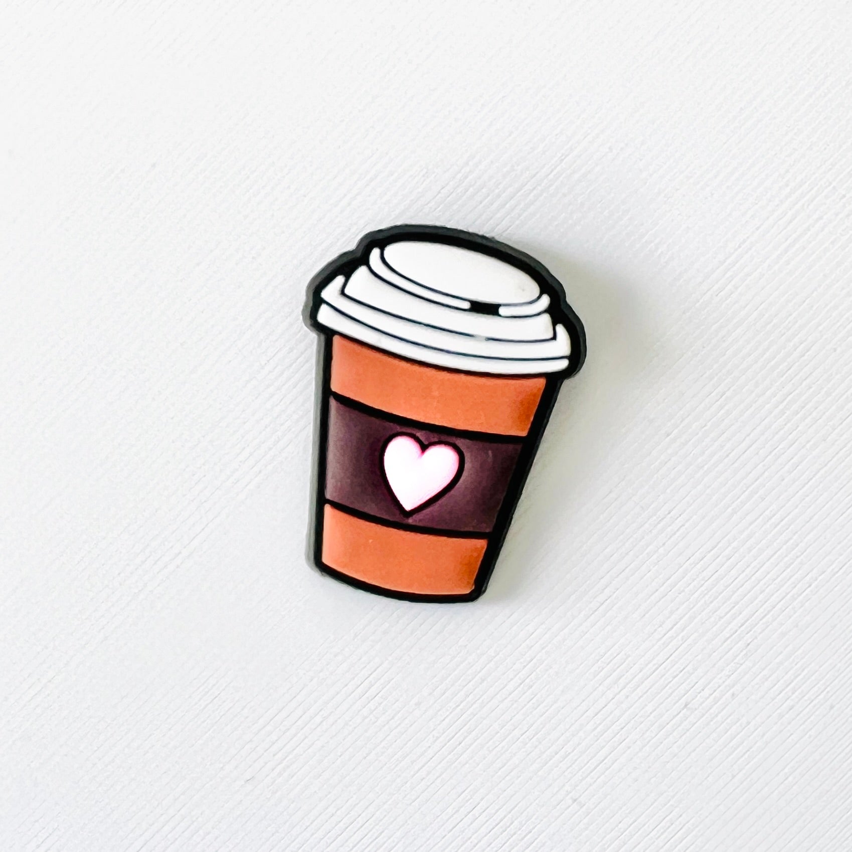 Charming coffee cup with a heart, featuring a stylish design, perfect for attaching to your favorite footwear.