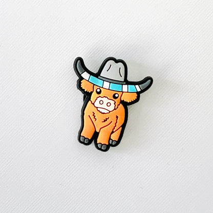 Adorable brown Highland cow wearing a cowboy hat, perfect for adding a fun western touch to your favorite shoes.