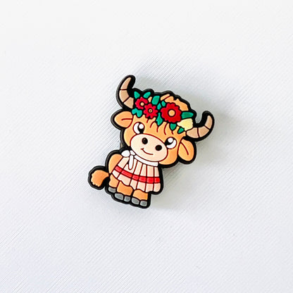 Adorable brown Highland cow with a colorful flower crown, perfect for adding charm to your shoes.