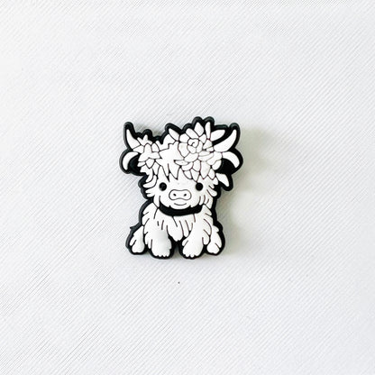 Adorable white Highland cow with flower accents, perfect for adding charm to clog-style shoes or as a gift for nature lovers.
