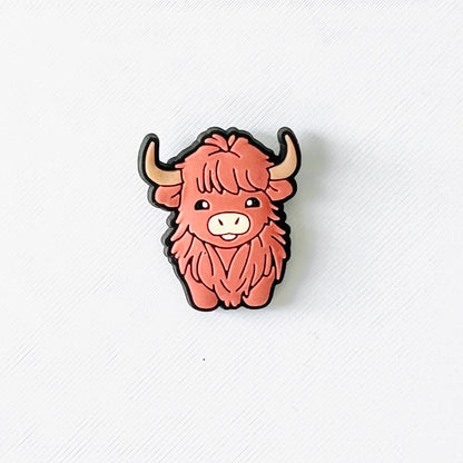 Adorable brown Highland cow charm with fluffy fur and a sweet expression, perfect for personalizing shoes.