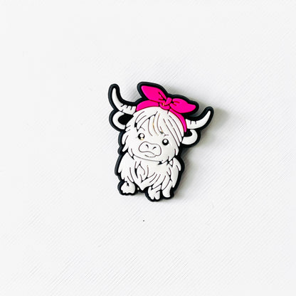 White Highland cow charm with a fluffy white coat and a cute pink headband, perfect for adding charm to shoes.