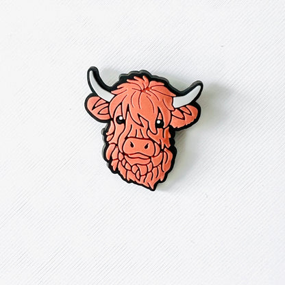 Adorable brown Highland cow face charm with fluffy features and gentle expression, perfect for adding charm to shoes.
