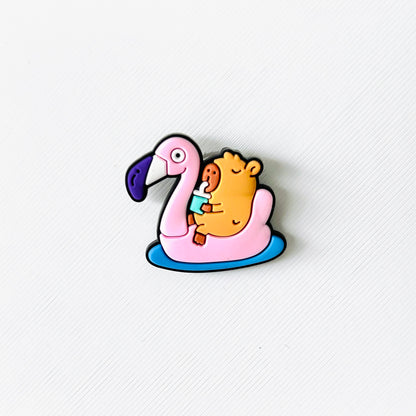 A cute capybara sipping a drink while lounging on a pink flamingo float, perfect for summer vibes.