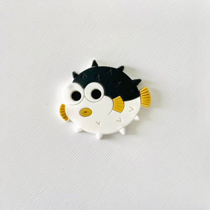 Adorable round puffer fish charm with spiky texture, big eyes, and vibrant fins, perfect for ocean lovers.