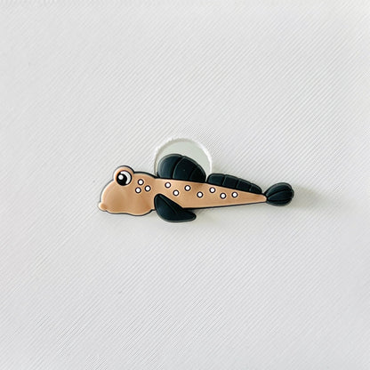 Spotted brown fish charm with white dots and black fins, perfect for ocean lovers and quirky accessories.